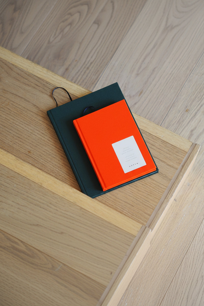 Black and orange notebook with a white label on a wooden surface